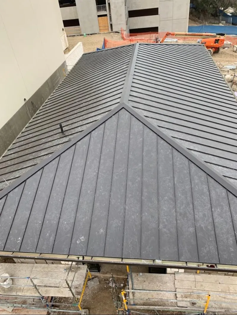 Commercial metal roof construction with crane equipment in Sandy